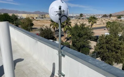 Professional white parabolic dish antenna mounted on a Las Vegas rooftop for reliable high-speed wireless business internet