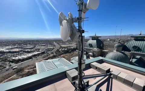 Fixed wireless dish antennas on a Las Vegas rooftop overlooking the city and desert mountains — high-speed internet without fiber