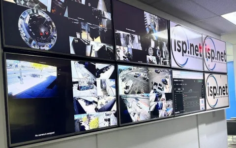 isp.net VisionNet monitoring wall with eight screens showing live security camera feeds and 24/7 remote viewing support